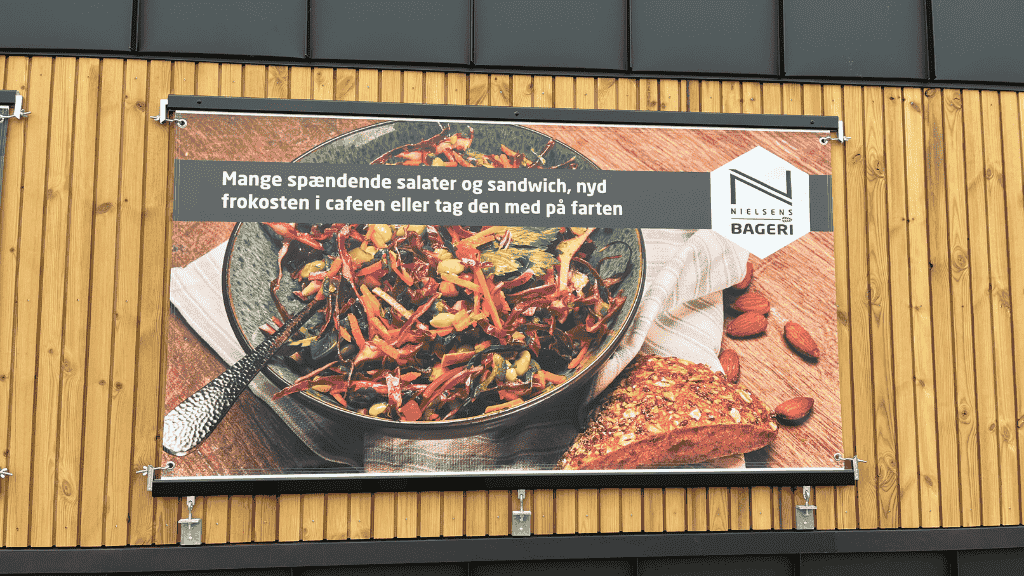 Skilt med blandet salat på facaden på Nielsens Bageri i Rødekro